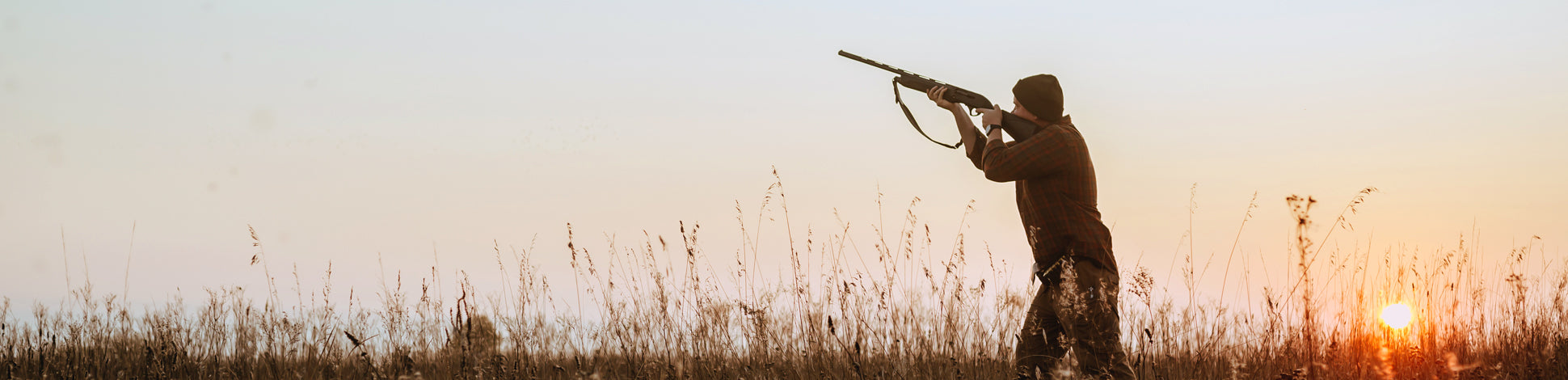 Man duck hunting with sunset in background